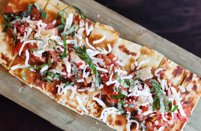 Flatbread with tomato, arugula and shaved cheese